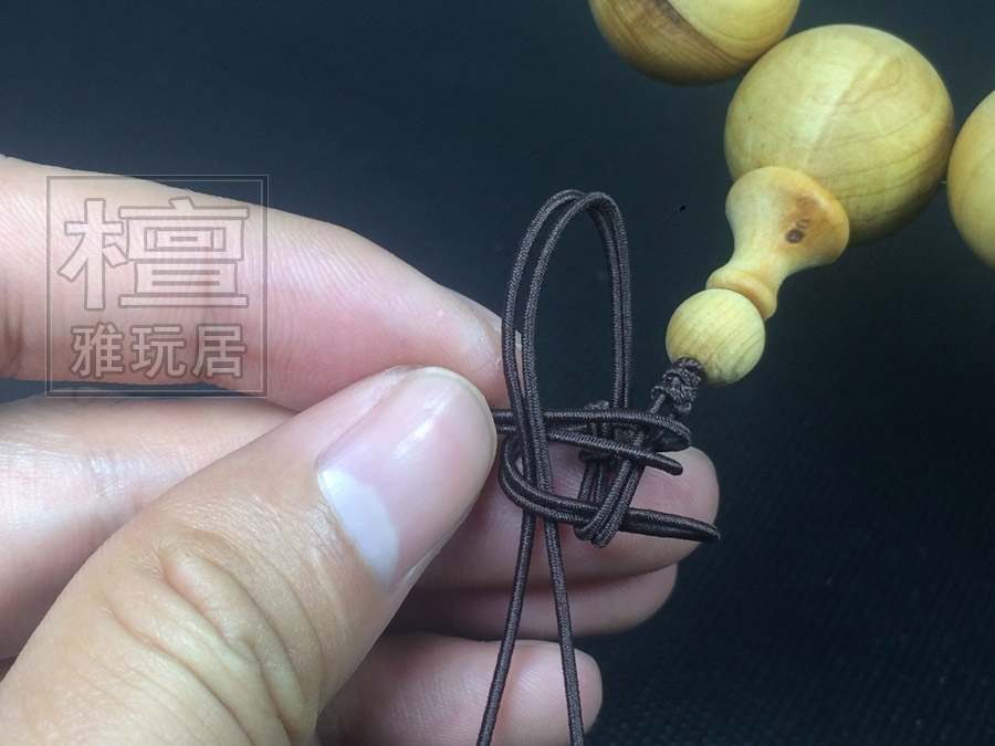 右边的往左翻，压着下面翻上来的线，并从上面的线孔中串过 