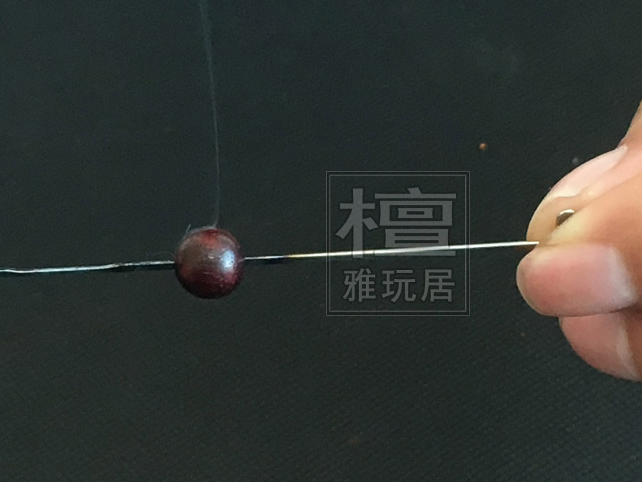 然后把珠子放到烧热的钩针处